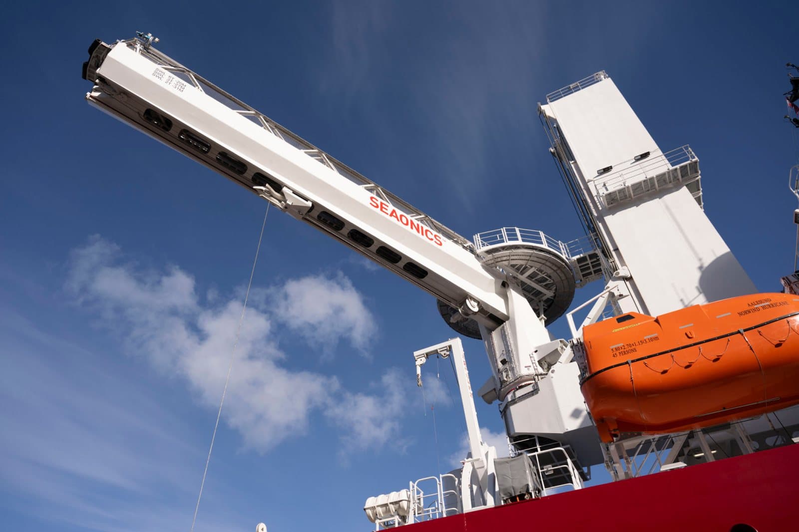 Offshore crane and lifeboat against blue sky